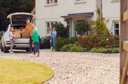 family-outside-new-home-on-moving-day-unloading-bo-2024-10-19-07-22-06-utc